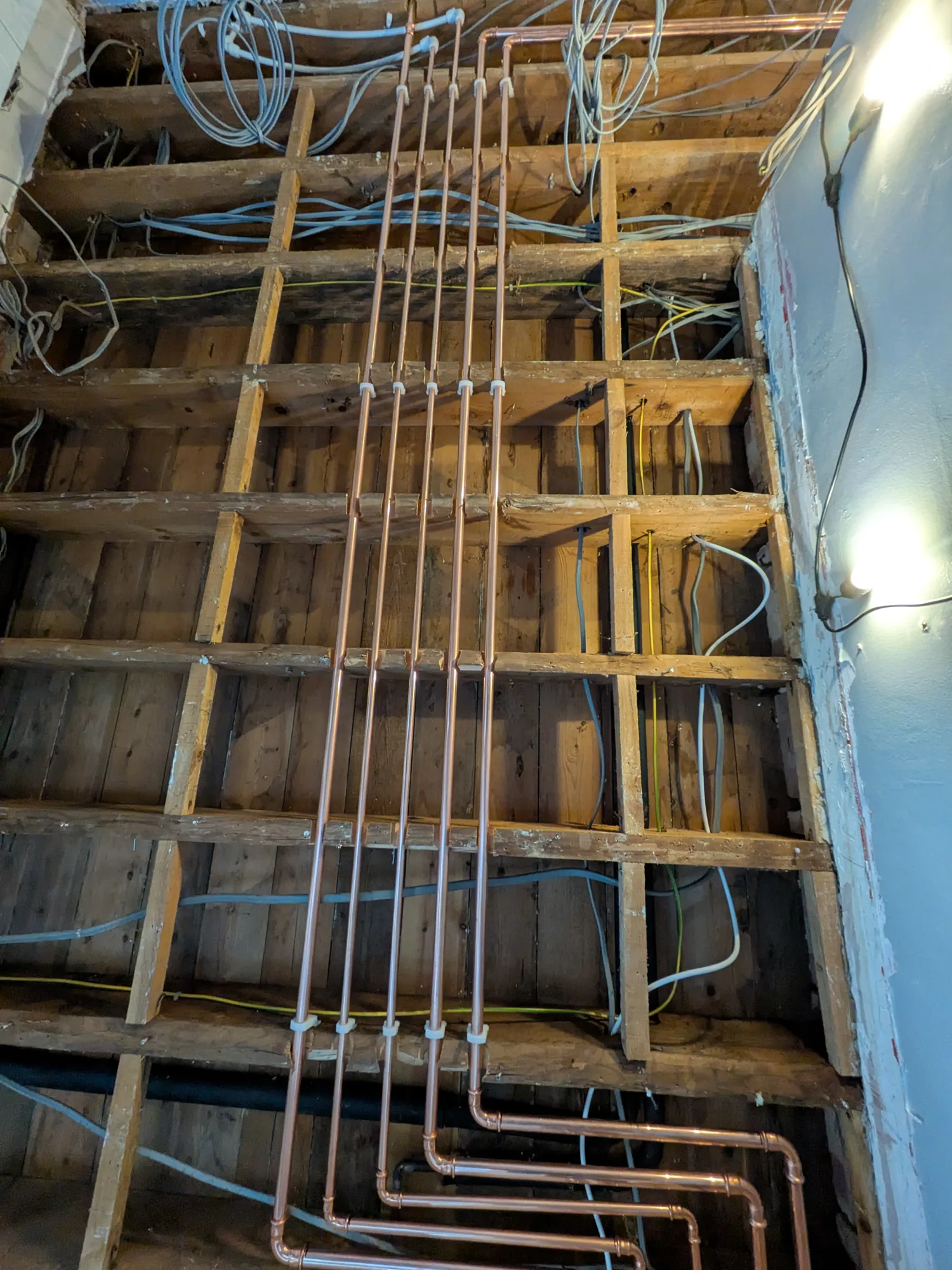 Underfloor heating first-fix pipework between floor joists